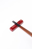 Svietiaci prachový červený držiak na paličky